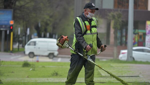 Работник коммунальных служб убирает газоны в Алматы - Sputnik Казахстан