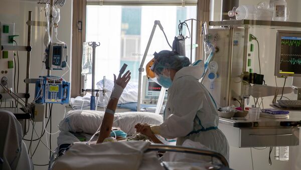 Медик поддерживает пациента в палате интенсивной терапии в больнице с коронавирусом - Sputnik Казахстан