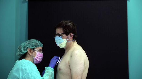 Врач осматривает пациента в защитной маске - Sputnik Казахстан
