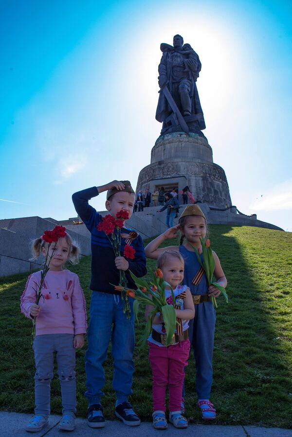 Дети на фоне монумента Воин-освободитель на территории мемориального комплекса в Трептов-парке в Берлине - Sputnik Қазақстан