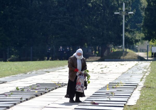 Женщина возлагает цветы к могилам советских воинов на военном кладбище Марсово поле во Львове - Sputnik Казахстан