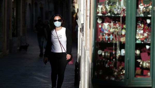 Девушка в маске прогуливается у магазина сувениров - Sputnik Казахстан