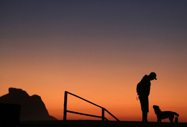 Мужчина во время прогулки с собакой на рассвете в Рио-де-Жанейро, Бразилия - Sputnik Казахстан