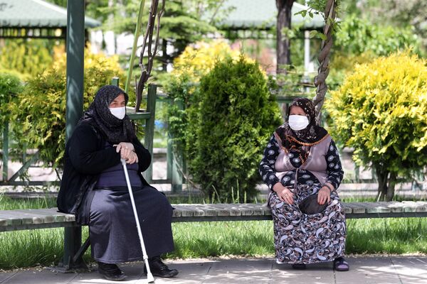 Пожилые женщины в медицинских масках на скамейке в одном из парков Анкары, Турция - Sputnik Казахстан