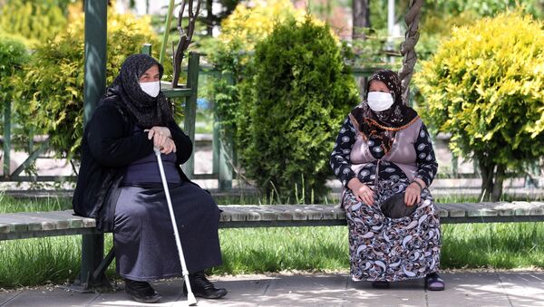 Пожилые женщины в медицинских масках на скамейке в одном из парков Анкары, Турция - Sputnik Казахстан