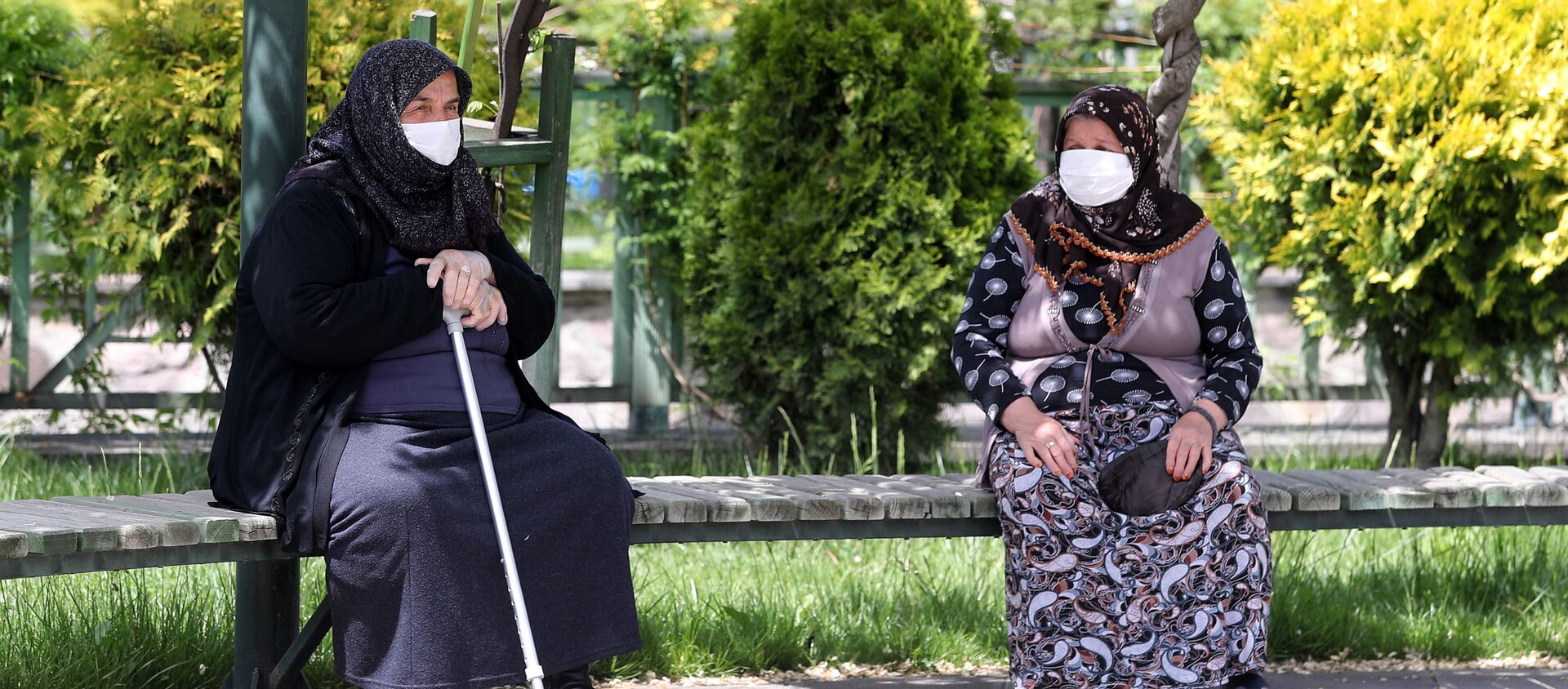 Пожилые женщины в медицинских масках на скамейке в одном из парков Анкары, Турция - Sputnik Казахстан, 1920, 26.04.2021