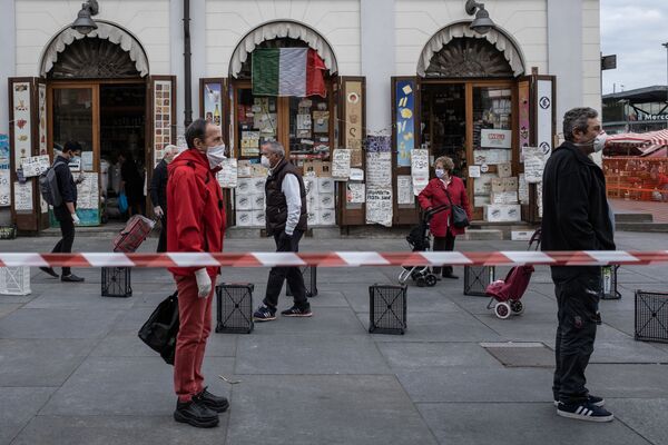 Люди соблюдают социальную дистанцию в очереди на продовольственном рыке Porta Palazzo в Турине, Италия - Sputnik Казахстан