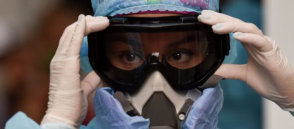 Девушка-медик поправляет защитные очки и респиратор в больнице с коронавирусом  - Sputnik Казахстан