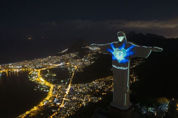 Статуя Христа-Искупителя с подсветкой в виде маски и надписью Маска спасает в Рио-де-Жанейро, Бразилия - Sputnik Казахстан