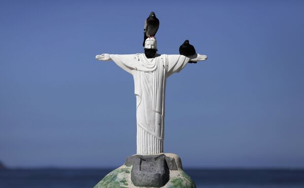 Статуя Христа-Искупителя, сделанная из песка, с защитной маской на пляже Копакабана в Рио-де-Жанейро, Бразилия - Sputnik Казахстан