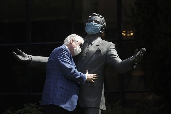Региональный вице-президент Fairmont Hotels обнимает статую певца Тони Беннетта возле отеля Fairmont San Francisco  - Sputnik Казахстан