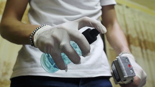 Сотрудница салона красоты обрабатывает антисептиком машинку для стрижки  - Sputnik Казахстан