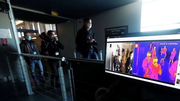 Люди в масках проходят дистанционное термосканирование на входе в здание  - Sputnik Казахстан
