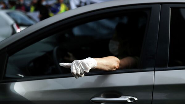 Мужчина в защитной маске и перчатках в автомобиле проезжает блокпост  - Sputnik Казахстан