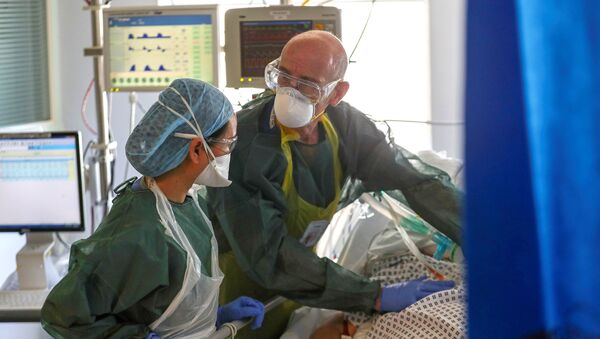 Врачи в защитных костюмах в палате интенсивной терапии в больнице с коронавирусом - Sputnik Казахстан
