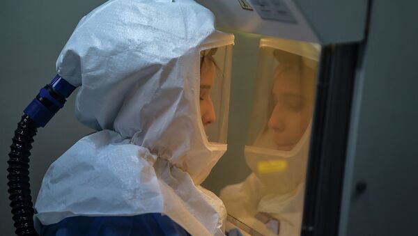 Сотрудница лаборатории в костюме биологической защиты работает с образцами коронавируса - Sputnik Казахстан