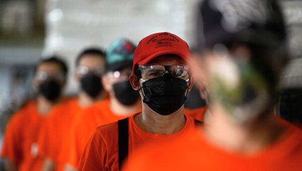 Молодые люди в защитных масках и очках выстроились перед входом в здание - Sputnik Казахстан