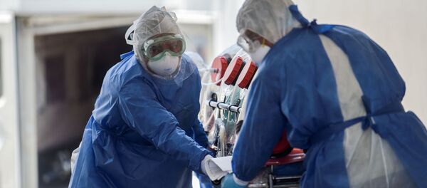 Врачи в защитных костюмах везут тяжелобольного в изоляционном боксе в палату интенсивной терапии в больнице с коронавирусом Врачи в защитных костюмах везут тяжелобольного в изоляционном боксе в палату интенсивной терапии в больнице с коронавирусом - Sputnik Казахстан