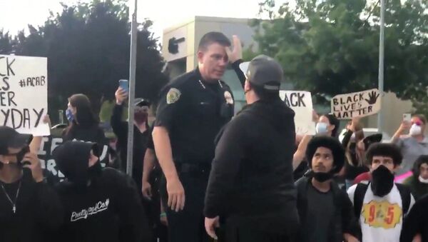 АҚШ-тағы наразылық: Калифорнияда америкалық полицей халық алдында тізе бүкті - Sputnik Қазақстан