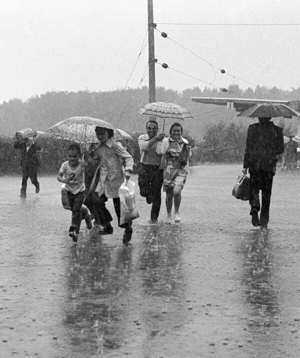 Жители города Тырныауз бегут под дождем - Sputnik Казахстан