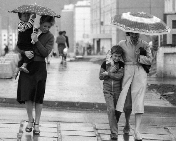 Прохожие идут по улице, прячась от дождя под зонтом - Sputnik Казахстан