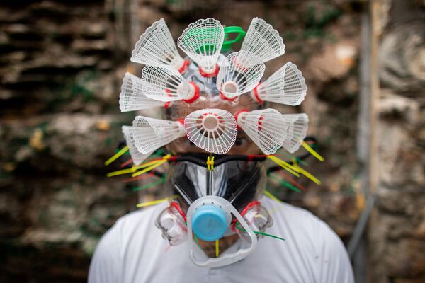 Филиппинский художник Leeroy New позирует в маске, которую он создал из переработанных материалов - Sputnik Казахстан