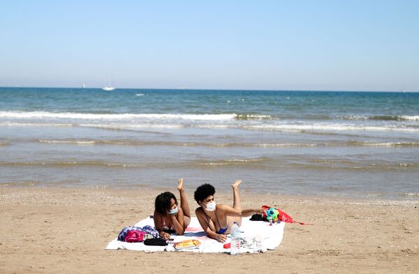 Девушки в защитных медицинских масках на пляже Malvarrosa в Валенсии, Испания - Sputnik Казахстан