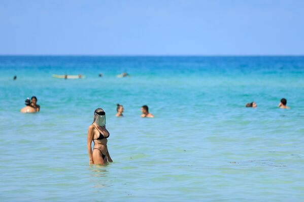 Женщина с защитным экраном на лице на пляже в Майами-Бич, Флорида - Sputnik Казахстан