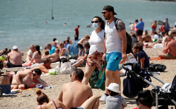 Пара в защитных масках на пляже в Саутенд-он-Си, Великобритания  - Sputnik Казахстан