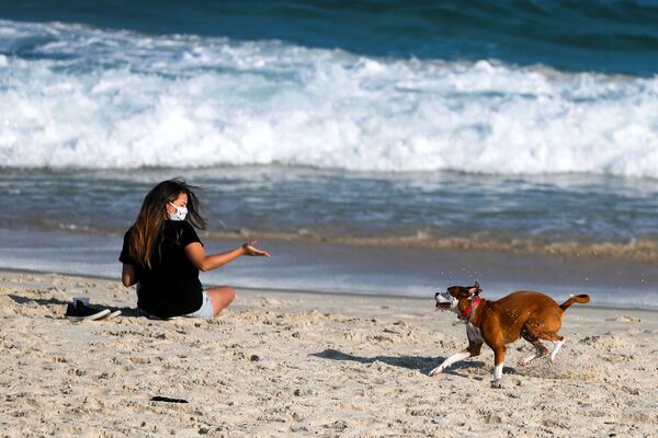 Девушка во время игры с собакой на пляже в Рио-де-Жанейро, Бразилия  - Sputnik Казахстан