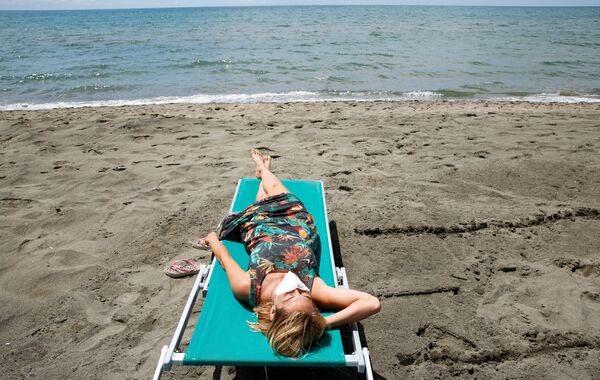 Девушка загорает на пляже в Италии - Sputnik Казахстан
