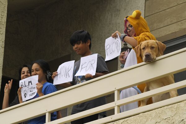 Люди и собака наблюдают с балкона за протестующими в Сими-Вэлли, Калифорния - Sputnik Казахстан