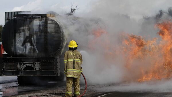 Пожарный тушит огонь на автоцистерне, архивное фото - Sputnik Казахстан