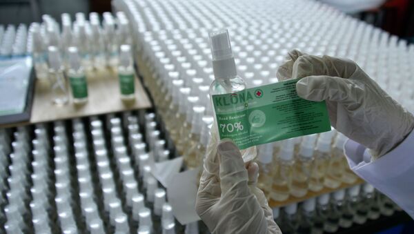 Сотрудник завода контролирует наклейку этикеток на флаконы с антисептиком  - Sputnik Казахстан