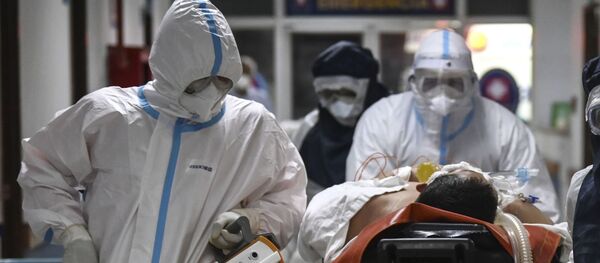 Врачи скорой помощи в защитных костюмах везут больного коронавирусом по коридору больницы - Sputnik Казахстан