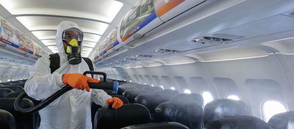 Сотрудник аэропорта проводит дезинфекцию салона самолета  - Sputnik Казахстан