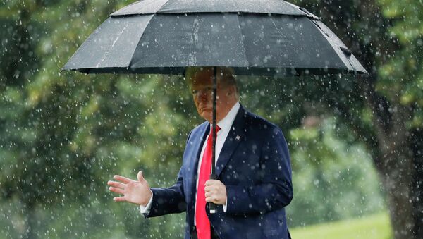 Президент США Дональд Трамп идет под зонтом во время дождя - Sputnik Казахстан