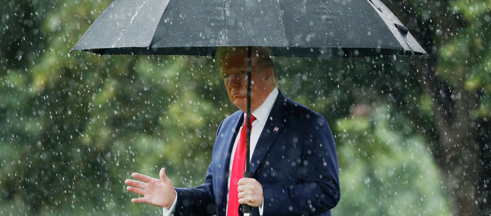 Президент США Дональд Трамп идет под зонтом во время дождя - Sputnik Казахстан, 1920, 07.08.2020