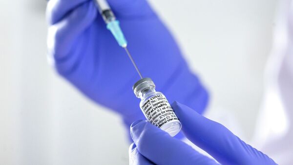 Сотрудник лаборатории набирает в шприц препарат во время испытания вакцины против коронавируса - Sputnik Қазақстан