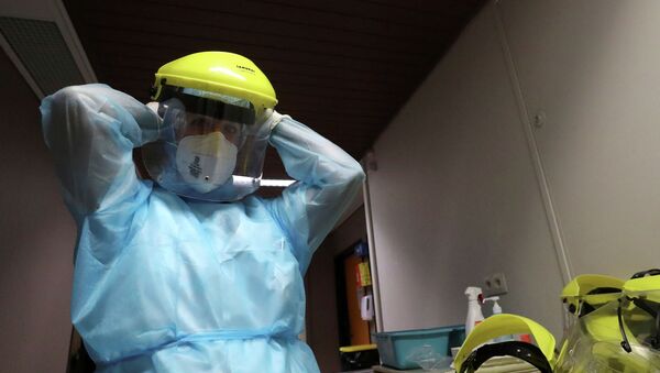 Медик надевает защитную маску в больнице с коронавирусом  - Sputnik Казахстан