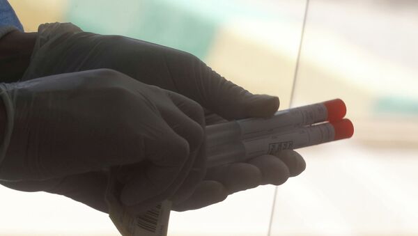 Медик держит в руках пробирки с пробами для анализа на коронавирус  - Sputnik Казахстан