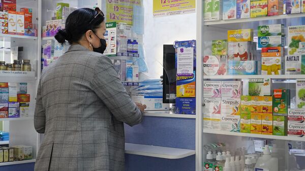 Женщина в маске покупает лекарства в аптеке - Sputnik Казахстан