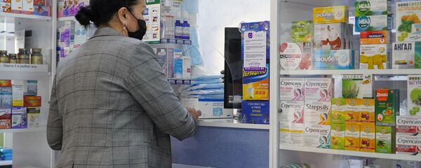 Женщина в маске покупает лекарства в аптеке Женщина в маске покупает лекарства в аптеке - Sputnik Казахстан