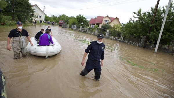 Сотрудники МЧС Украины эвакуируют жителей затопленного села Ланчин в Ивано-Франковской области - Sputnik Казахстан