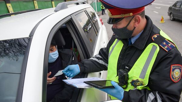 Полицейский в маске проверяет документы водителя - Sputnik Казахстан