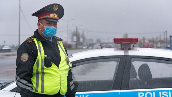 Полицейский в маске на дороге под дождем - Sputnik Казахстан