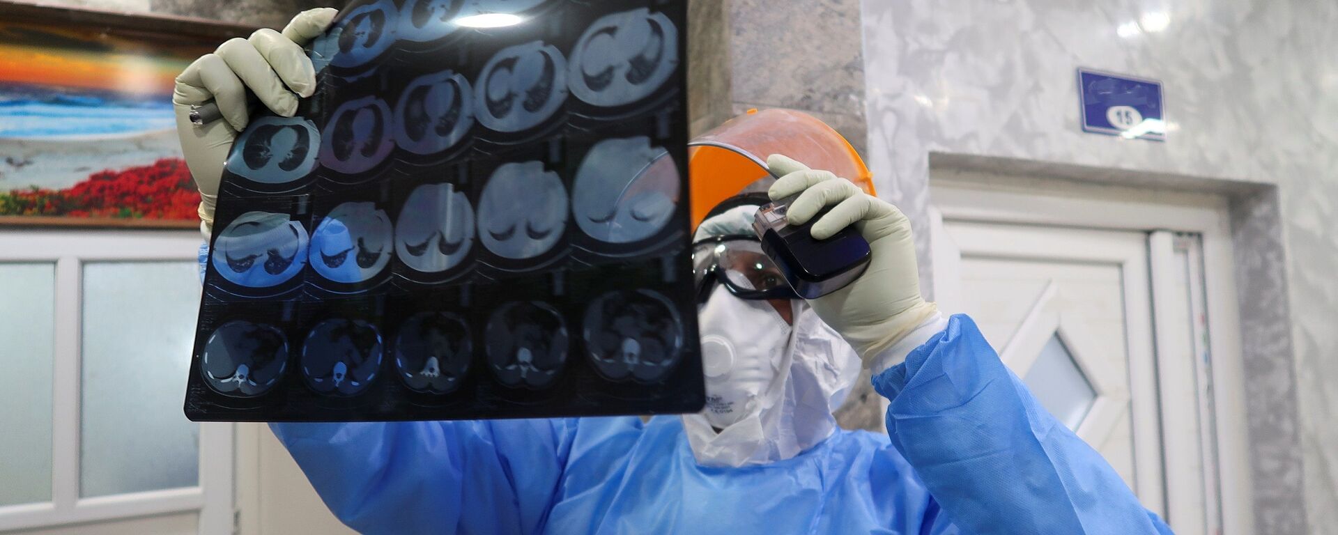 Медик в защитном костюме смотрит результаты МРТ в  больнице с коронавирусом - Sputnik Казахстан, 1920, 26.04.2022