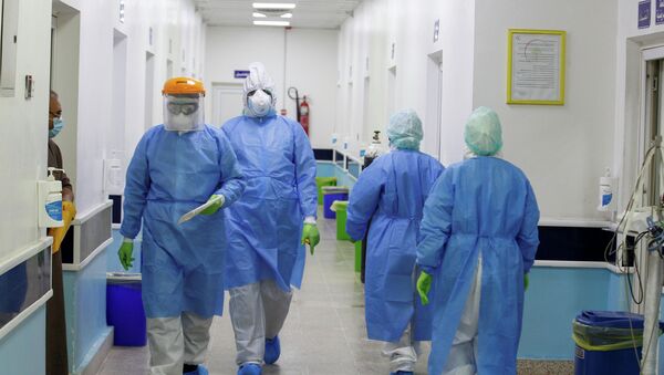 Медики в защитных костюмах в коридоре больницы с коронавирусом - Sputnik Казахстан