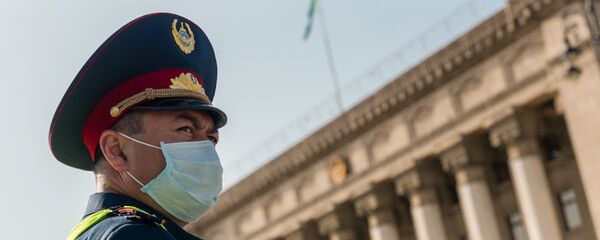 Полицейский в маске на площади Астана в Алматы Полицейский в маске на площади Астана в Алматы - Sputnik Казахстан
