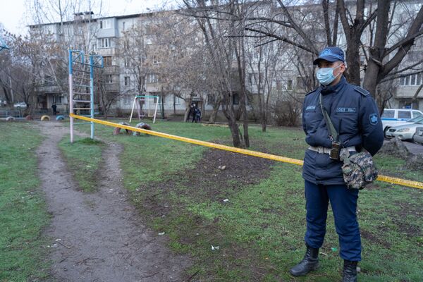 Полицейский у огороженной детской площадки дома, закрытого на карантин, архивное фото - Sputnik Казахстан